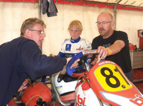 Mekaniker Paw Madsen, Bo Sørensen og teamchef Erik Sørensen diskuterer omgangstiderne ved karting-løb på Spa.